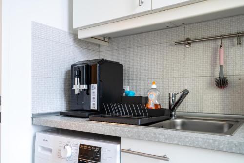 a kitchen counter with a sink and a microwave at revLIVING Apartments Eggenburg in Eggenburg