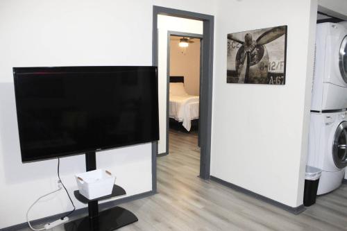 einen Flachbild-TV auf einem Stand in einem Wohnzimmer in der Unterkunft Just Enough in McDonough