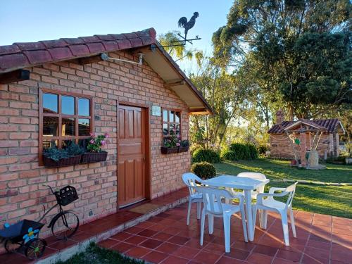 un patio con mesa y sillas y un edificio en Mano de Oso Guasca son 3 hospedajes diversos en la ruralidad en Guasca