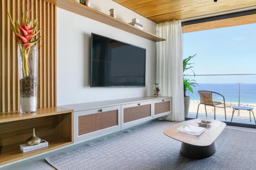 a living room with a flat screen tv on a wall at Loft Exclusive frente Mar in Rio de Janeiro