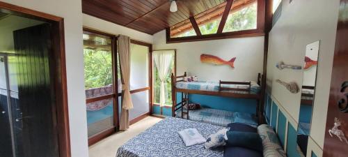 um quarto com uma cama e uma janela em Manacá Suítes Prumirim em Ubatuba