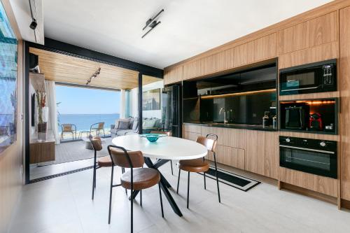 a kitchen and dining room with a table and chairs at Loft Exclusive frente Mar in Rio de Janeiro