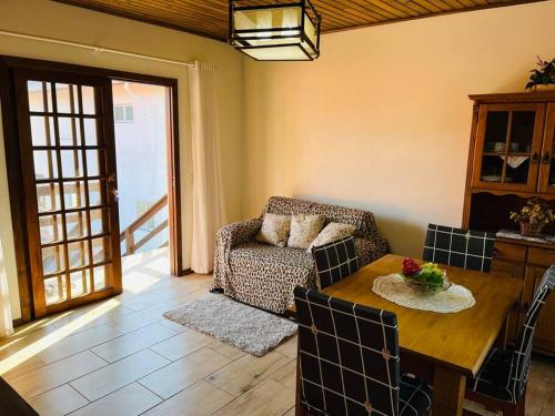 een woonkamer met een tafel en een bank bij Ap com Sacadas, 02 quartos e churrasqueira in Palhoça