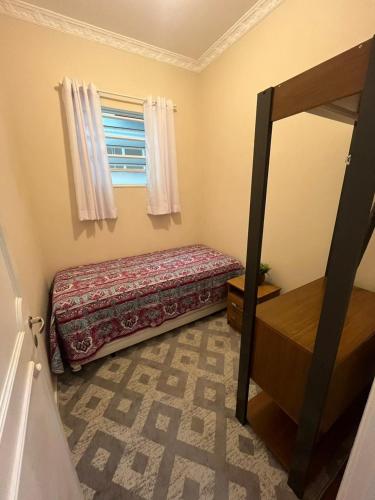 a small bedroom with a bed and a window at Apartamento Imperial no Centro de Petrópolis in Petrópolis