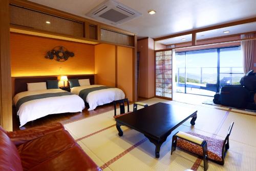 a living room with two beds and a table at 別所温泉 七草の湯 in Ueda