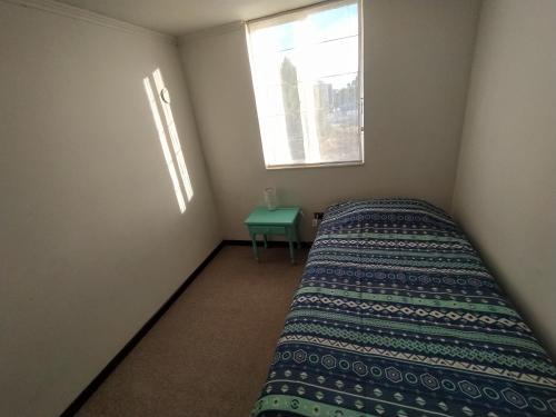 a small bedroom with a bed and a window at Vista los poetas in Temuco