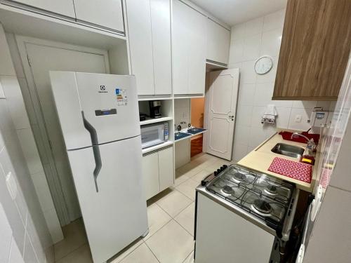 uma cozinha com um frigorífico branco e um fogão em Apartamento Imperial no Centro de Petrópolis em Petrópolis