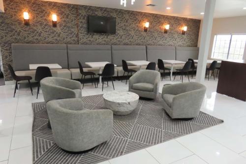 a dining room with chairs and tables and a tv on a wall at Best Western SeaWorld San Antonio in San Antonio