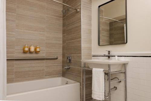 a bathroom with a tub and a sink and a mirror at Hotel Bijou - Union Square in San Francisco