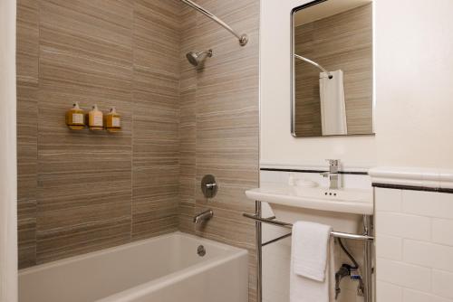 a bathroom with a tub and a sink and a mirror at Hotel Bijou - Union Square in San Francisco