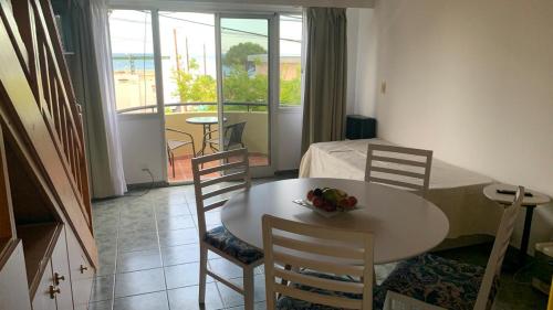 a room with a table and chairs and a bedroom at Amaneceres frente al Mar Dpto 2 in Puerto Madryn