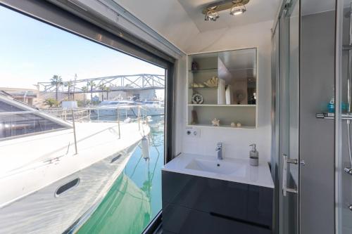 een badkamer met een wastafel en een groot raam bij Unique in Barcelona ! Catamaran with a private swimming pool in Barcelona