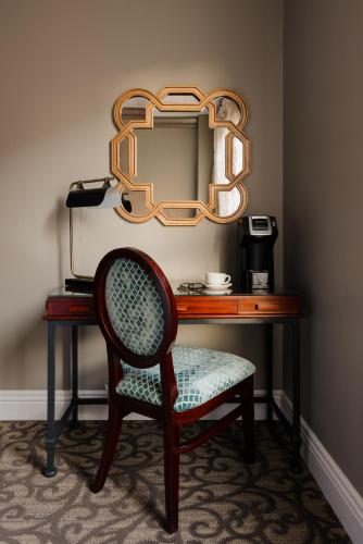 a chair sitting in front of a desk with a mirror at Hotel Bijou - Union Square in San Francisco