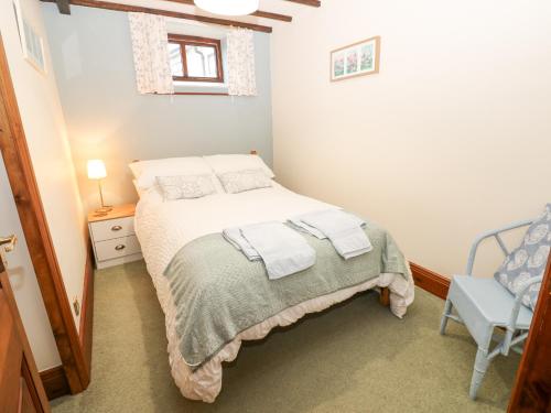 a small bedroom with a bed and a chair at Mordon Moor Cottage in Stockton-on-Tees