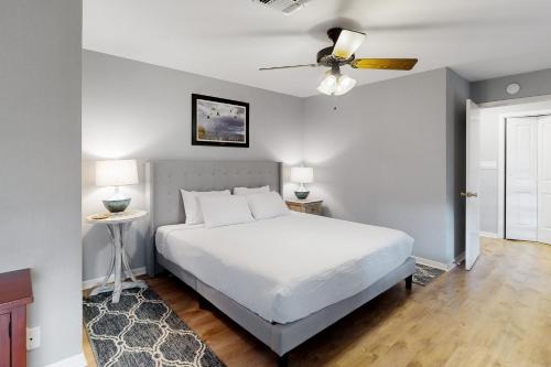 - une chambre avec un lit blanc et un ventilateur de plafond dans l'établissement Getaway on the Bay, à Rockport