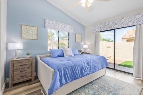 Dreaming in the Desert في ميسا: غرفة نوم زرقاء مع سرير ونافذة كبيرة