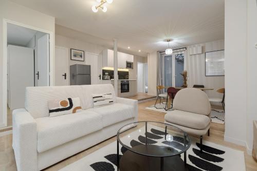 un salon avec un canapé blanc et une table en verre dans l'établissement Poetic Stay - Montmartre, à Paris