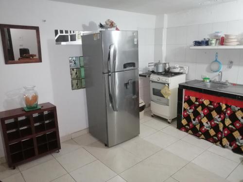a kitchen with a stainless steel refrigerator and a stove at Casa de relajación low cost in La Dorada