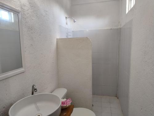 ein weißes Bad mit einem WC und einem Waschbecken in der Unterkunft Club Cadena in Acapulco