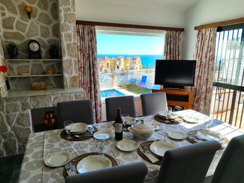mesa de comedor con vistas al océano en Villa Las Mercedes - Urbanización El Castillo en Fuengirola