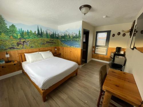 Salmon的住宿－Sacajawea Inn，卧室配有一张床,墙上挂有绘画作品