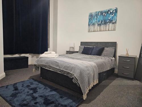 a bedroom with a bed and a painting on the wall at Bloomsbury Apartments - Leicester in Leicester