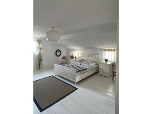 a white bedroom with a bed and a table at Vincent family holiday home in Niederdorf