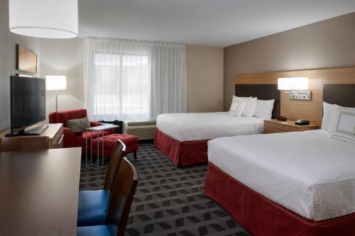 a hotel room with two beds and a television at TownePlace Suites by Marriott Richmond in Richmond