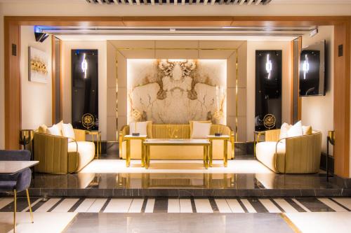 a lobby with gold furniture and a painting on the wall at فندق كلاودز Clouds Hotel in Al Madinah