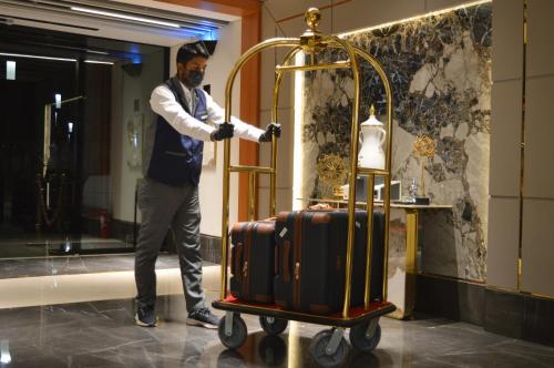 Um homem está ao lado de um carrinho de bagagem. em فندق كلاودز Clouds Hotel em Medina