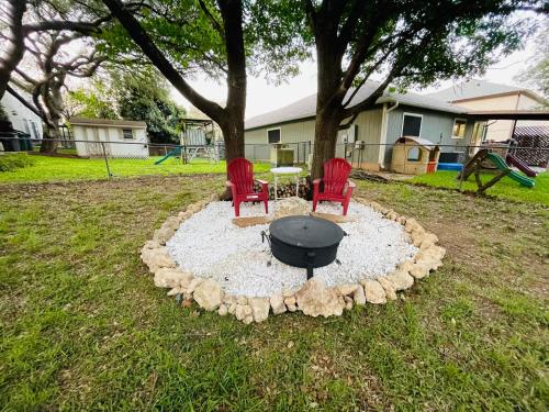 a fire pit in a yard with two chairs and a table at Lost Bluff Casa in San Antonio