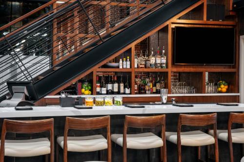 a bar with chairs and a tv in a room at Residence Inn by Marriott Norwalk in Norwalk