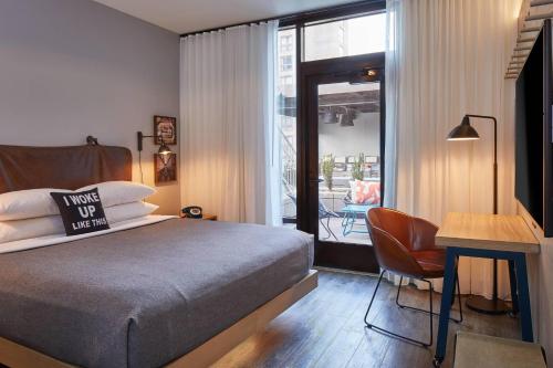a bedroom with a bed and a table and a chair at Moxy Atlanta Midtown in Atlanta