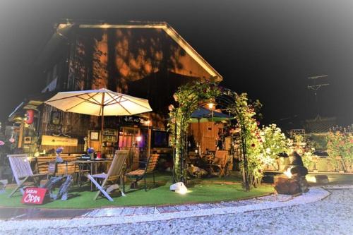 佐渡市的住宿－Natural Mind Tour - Vacation STAY 94017v，一座带桌子和雨伞的建筑