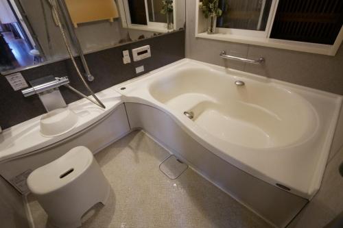 łazienka z białą wanną i toaletą w obiekcie Natural Mind Tour - Vacation STAY 56703v w mieście Sado