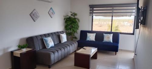 a living room with a blue couch and a window at punta diamante nuevo altata sin. in Altata