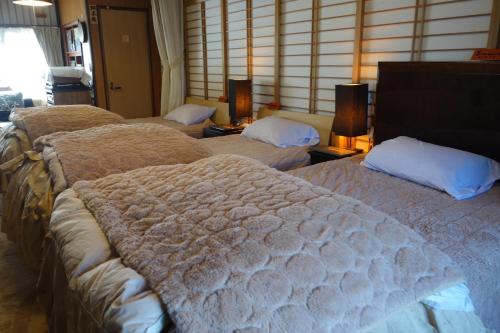 a group of beds in a hotel room at Natural Mind Tour guest house - Vacation STAY 22268v in Sado