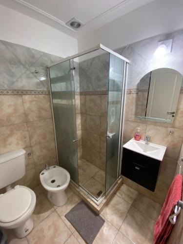 Un baño con ducha, inodoro y lavabo. en Departamentos Tomás Mason, en Santa Rosa
