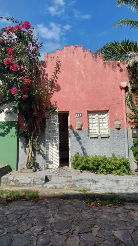 een rood huis met een boom ervoor bij Cantinho das Olandas in Olinda