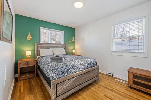 1 dormitorio con cama y pared verde en Elm. Peaceful pet friendly home. No pet fee!, en Omaha