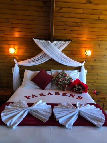 a bedroom with a bed with bows on it at Chalés do Gigante in Pardinho