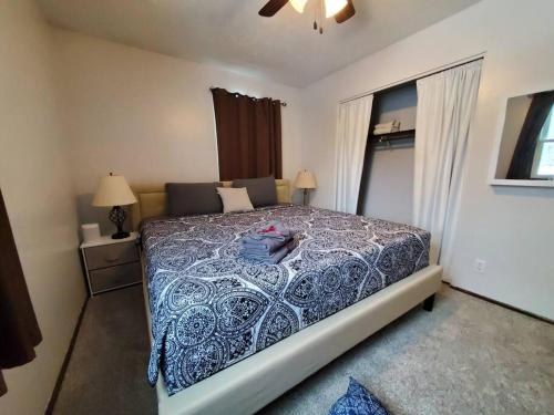 a bedroom with a bed with a blue comforter at Maple. Pleasant 4 bedroom house with pool in Omaha
