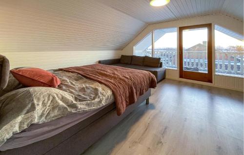 a bedroom with a bed and a couch and a window at Nice Home In storp With Kitchen in Åstorp