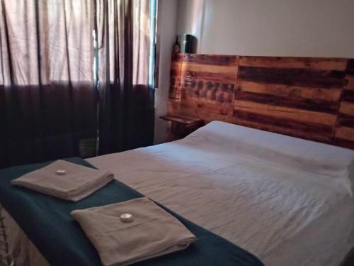 uma cama com duas toalhas em cima em Hostal La Palmera em Ezeiza
