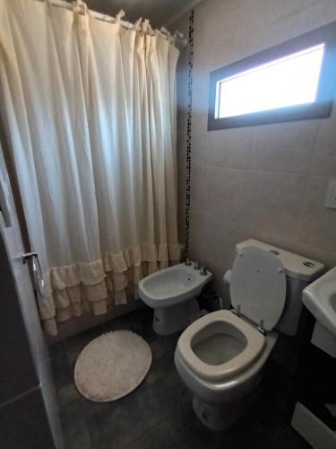 baño con aseo y lavabo y ventana en Mono Ov. LAGOS 2 en Rosario