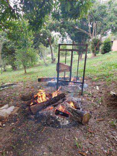 einen Stuhl über einem Lagerfeuer auf einem Feld in der Unterkunft Chácara Goufran in Caçapava