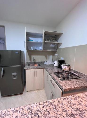 una cucina con piano cottura e frigorifero di 306 Confortable y lindo apartamento a Cali
