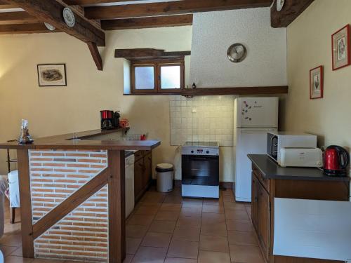 a kitchen with a counter top and a stove at Gîte en Sologne avec Étang Privé, Pêche et Proximité des Châteaux de la Loire - FR-1-590-39 in Ligny-le-Ribault