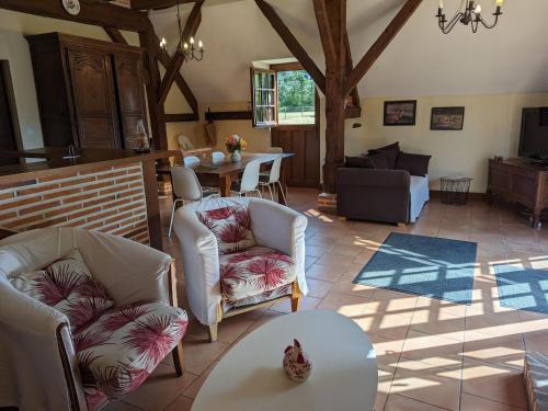 a living room with white chairs and a table at Gîte en Sologne avec Étang Privé, Pêche et Proximité des Châteaux de la Loire - FR-1-590-39 in Ligny-le-Ribault