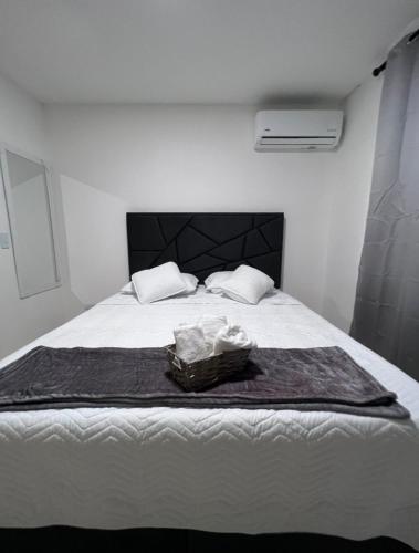 una camera con letto bianco e testiera nera di 306 Confortable y lindo apartamento a Cali